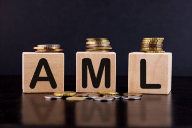AML 'nin kısaltması para aklama karşıtı, tahta bloklardaki madeni paralar. Yozlaşma yok.