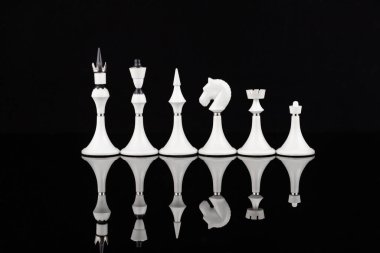 Yansıtıcı yüzeyde beyaz satranç taşları. İş konsepti. Oyun, strateji, bilgelik, kararlılık.