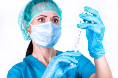 Doktor ya da profesyonel şırınga ve şırınga. Şırınga, elinde tıbbi enjeksiyon, iğneyle aşı malzemesi. Ya doktor ya da tıbbi korucu giyen bir sağlık uzmanı. Doktor elinde şırınga tutuyor.