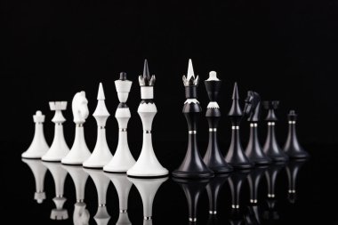 Satranç taşları yansıtıcı yüzeyde sıralanmış. İş konsepti. Oyun, strateji, bilgelik, kararlılık.