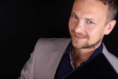 Bir işadamı dijital tableti üzerinde çalışıyor. Siyah bir arkaplan üzerinde. İş konsepti, fikir.