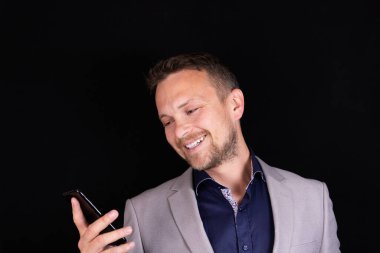 İş adamı elinde bir cep telefonu tutuyor ve konuşmadan duyduğu duyguyu dile getiriyor. İş konsepti