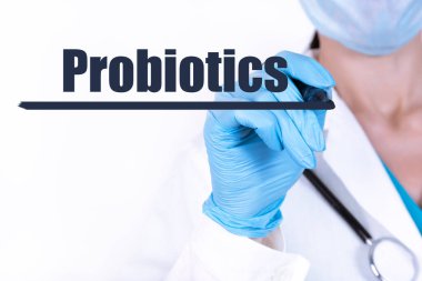 PROBIOTICS metni steteskoplu bir doktor tarafından tutulan bir kalemle yazılır. Tıbbi konsept.