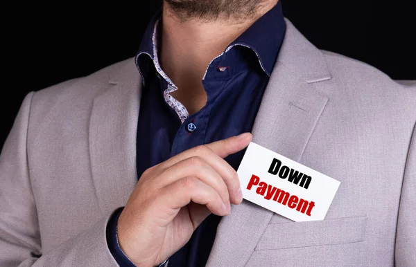Businessman put card with text DOWN PAYMENT in pocket. Business concept.