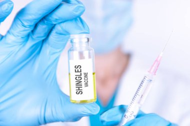 Metin Şıngır VACCINE tıbbi eldiven ve maskeli bir doktorun geçmişine sahip bir şişeye yazılır. Tıbbi konsept.