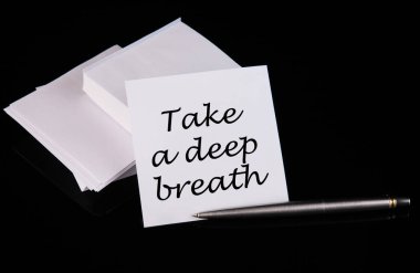 Kavramsal el yazısı. Siyah bir masanın üzerindeki beyaz etikete derin bir nefes al..