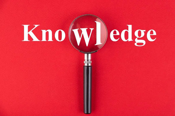 Knowledge文字是通过红色背景的放大镜写成的 商业教育概念 — 图库照片