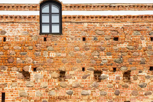 The surrounding wall of the old European castle Mir. Stone wall background.