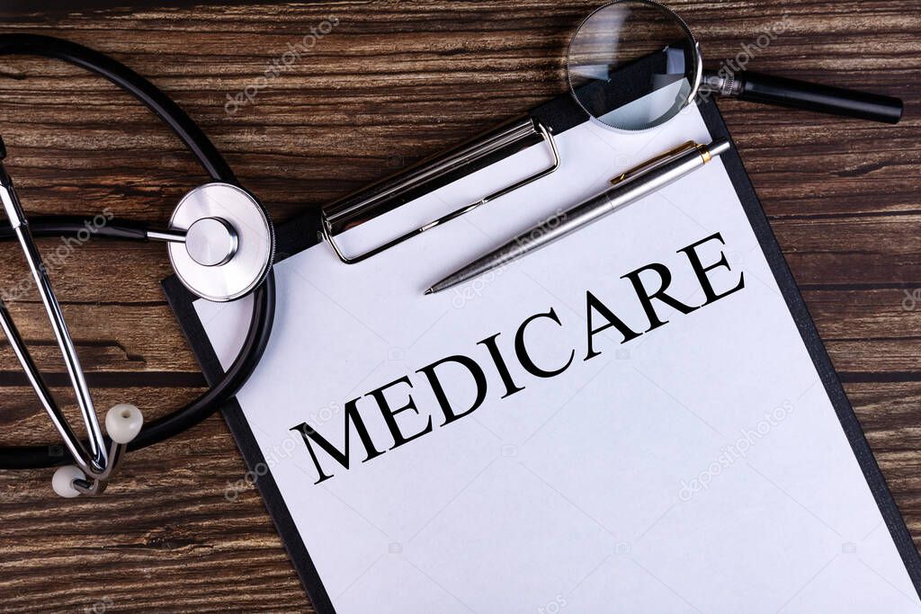 MEDICARE text written in a notebook lying on a desk and a stethoscope. Medical concept.