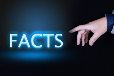 FACTS metni, siyah arkaplan üzerinde neon harflerle yazılmış bir kelimedir. Bir kişinin işaret parmağıyla işaret edilir..
