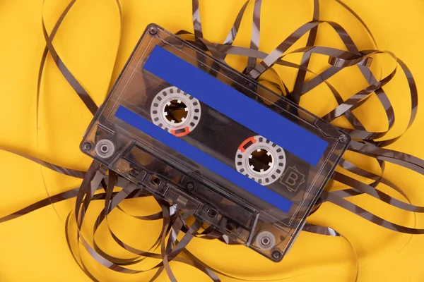黄色の背景に傷のないテープと古いカセットテープ — ストック写真