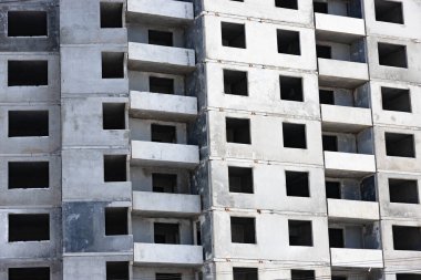 İnşaat halindeki binanın beton cephesi. Balkonlar ve camsız pencereler. Sivil inşaat konusunda arka plan ya da duvar kağıdı