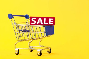 Boş mini alışveriş arabası, alışveriş arabası, sarı arka planda kısa mesaj. RFI bilgi talep ediyor. Boşluğu kopyala