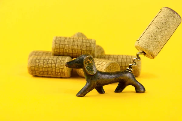 アンティーク日付のワインのコルクと古いコルク栓のグループのクローズアップ ダックスフンド犬の形で 黄色の背景で スペースのコピー — ストック写真