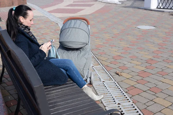 Ung Kvinna Går Parken Våren Med Barnvagn Mamma Tittar Mobiltelefon — Stockfoto