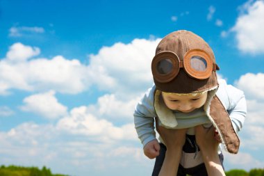 Yakın plan, bebek pilot, pilot şapkası, miğfer, genç ve güzel bir esmer kızın ellerinde. Boşluğu kopyala.