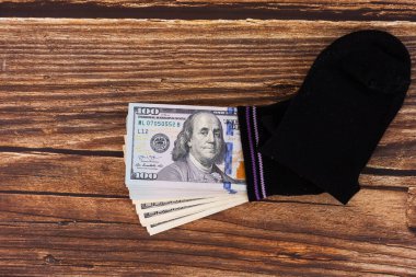 Bir para çorabı, çorabın içine gizlenmiş 100 dolarlık banknotlar. Tasarruf ve depolama kavramı. Boşluğu kopyala.