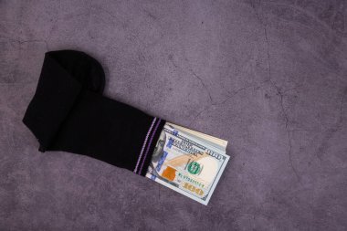 Bir para çorabı, çorabın içine gizlenmiş 100 dolarlık banknotlar. Tasarruf ve depolama kavramı. Boşluğu kopyala.