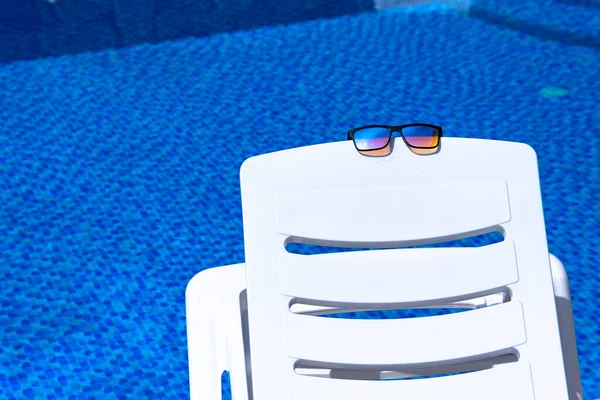 Sunglasses Lie White Chaise Lounge Backdrop Pool Blue Water Copy — Stock Photo, Image