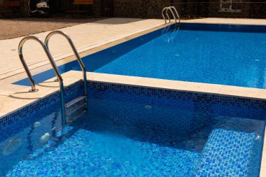 Mavi suyu olan açık havuzda insanlar yok..