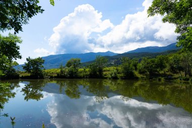 Kırım 'da küçük bir dağ gölü bulutlu dağların arka planına karşı. Peyzaj.