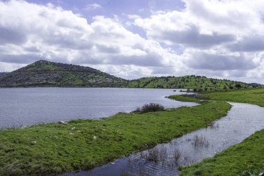 Ufukta tepe olan yapay bir göl.