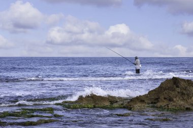 Balıkçılar Akdeniz kıyısında gelgitte balık yakalıyor.