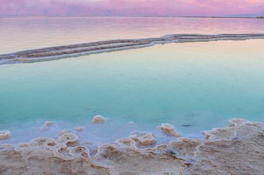 Ölü Deniz 'de gün batımı. Tuz oluşumları. Dağ sırası