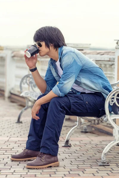 Guy wearing cargo pants and drinking a coffee