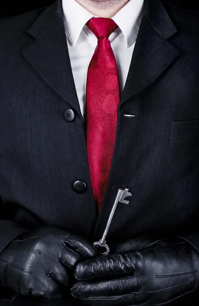 Man in black with a key — Stock Photo, Image