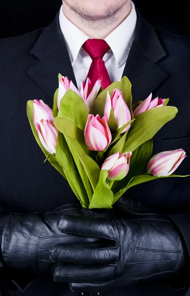 Man in black with flowers — Stock Photo, Image