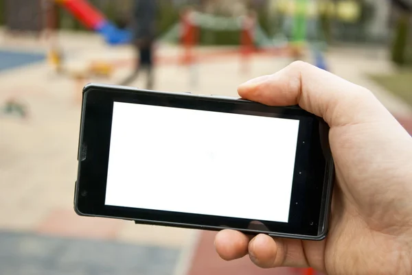 Smartphone und Spielplatz — Stockfoto