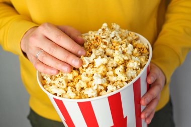 Film izlemeye hazırlanan bir adamın elinde patlamış mısır kovası. Şov zamanı. Lezzetli, sağlıksız, tatlı abur cuburlar. Yeni bir film için sinemaya gidiyorum. Dinlenme ve eğlence. Patlamış mısır yakın çekim