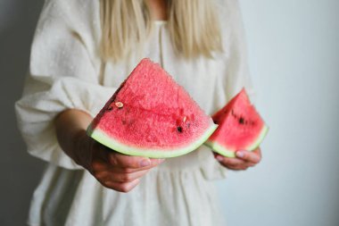 Mutlu bir kadının ellerinde sulu karpuz dilimi. Tropik meyve diyeti. Olgun karpuz yakın çekim. Lezzetli yaz meyveleri. Düzgün beslenme. Taze vitamin tatlısı. Sağlıklı yaşam tarzı