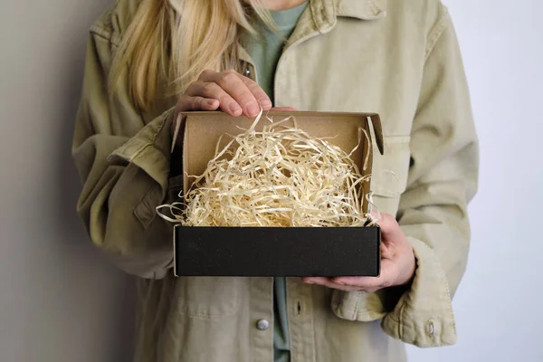 女人手里拿着小黑纸盒 带着新包裹的小女孩盒子特写 是时候打开节日礼物了邮政服务 牛皮纸礼品盒 礼物纸箱案 — 图库照片