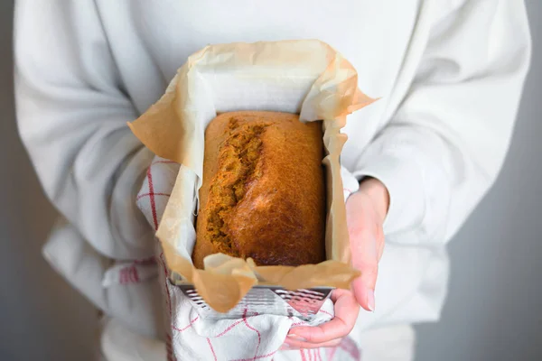 Fresh bread from the oven in the hands of a woman baker. Fragrant crispy pastries for breakfast. Making delicious homemade bread. Natural products and healthy food. Gluten free