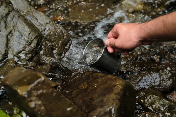 Der Mensch Nimmt Kaltes Wasser Aus Einem Gebirgsfluss Einen Wanderbecher — Stockfoto