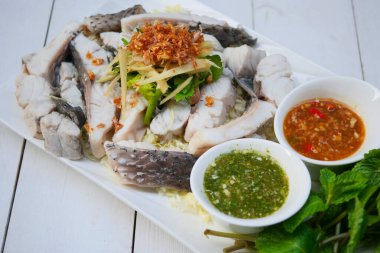 Soslu ve sebzeli haşlanmış balık sosu.