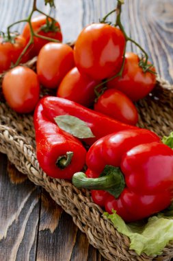 Olgun kırmızı sebzeler masada hasır bir tabakta