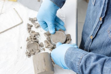 Mavi lateks eldivenli ellerin üst görüntüsü laboratuvar testleri için kil dairesel kesim için metal bir halka basıyor.
