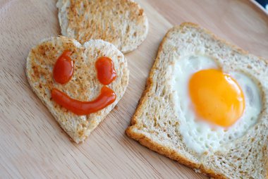 mutlu yüz üzerinde kalp şeklinde ekmek kesme. Konsept hakkında