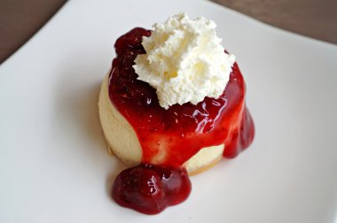 Kırbaçlanan krem beyaz tabakta ile çilekli cheesecake