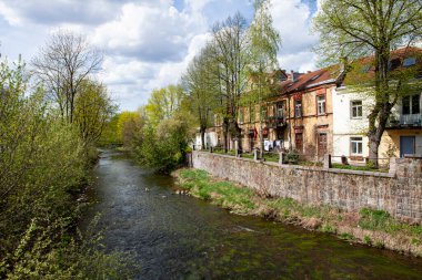 Vilnius, Uzupis 'teki Vilnia nehri kıyısındaki otantik eski kasaba evleri güneşli bir bahar gününde tarihi turlar için popüler bir yerdir..