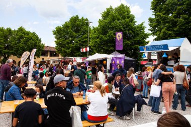 FLORENCE, ITALY - 25 Nisan 2025: İnsanlar Fortezza da Basso 'daki Mostra Internazionale dellArtigianato' da (Uluslararası El Sanatları Sergisi) İtalyan sokak yemeklerini ve sosyalleşmeyi seviyorlar.