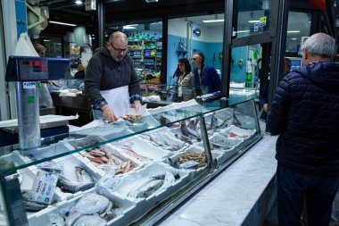 FLORENCE, ITALY - 26 Nisan 2025: Yerel halk ve turistler için popüler bir yer olan tarihi Mercato Centrale 'deki balıkçı dükkanında geniş bir yerel deniz balığı ve deniz ürünleri seçimi.