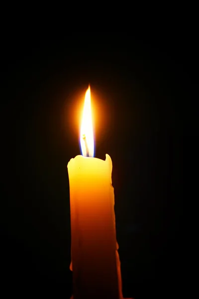 Burning candle on a black background — Stock Photo, Image