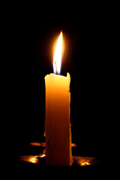 burning candle on a black background