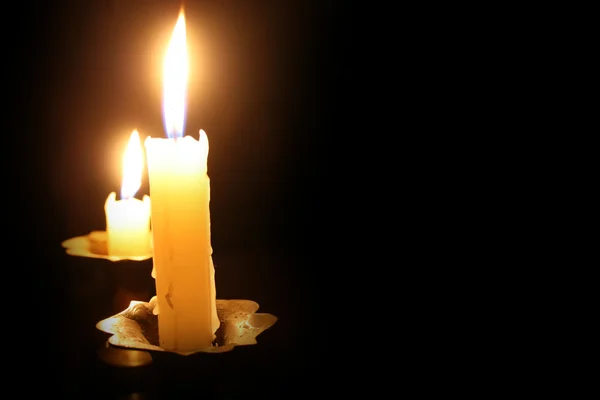 Płonąca świeca na czarnym tle — Zdjęcie stockowe