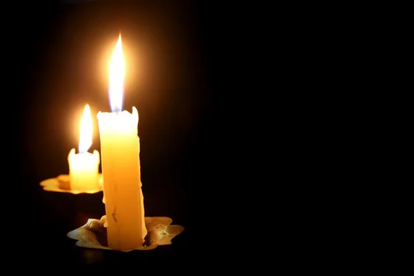 Burning candle on a black background Stock Picture