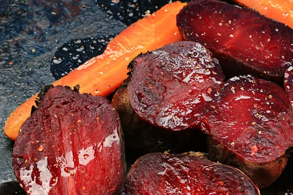 Roasted vegetables beets carrots dark background selective focus toning rustic old style — Stock Photo, Image